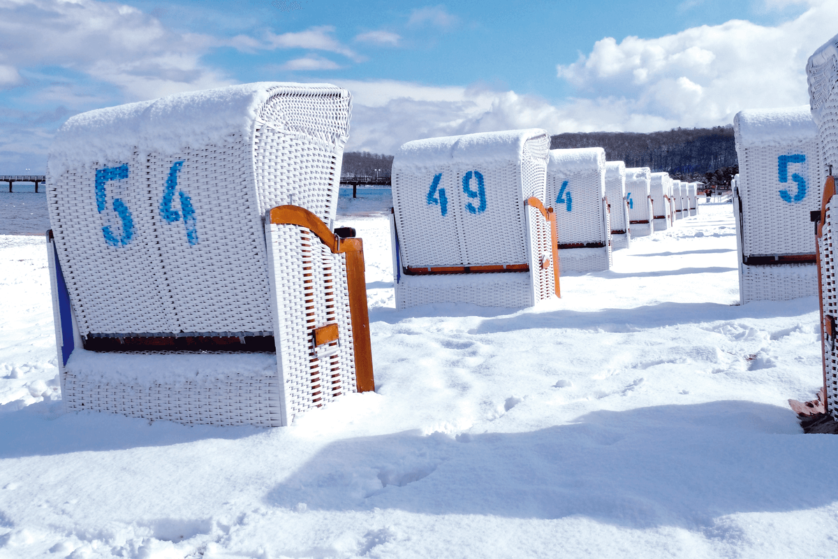 Schneebdeckte Strandkörbe am Ostseestrand von Rügen